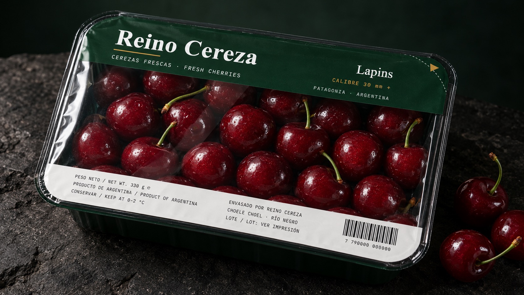 Bandeja Reino Cereza sellada, sobre piedra oscura, con cerezas sueltas al lado